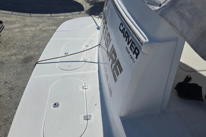 Slide: The Image of 2000 Carver 450 Voyager Pilothouse boat stern with storage hatches and branding. - 10