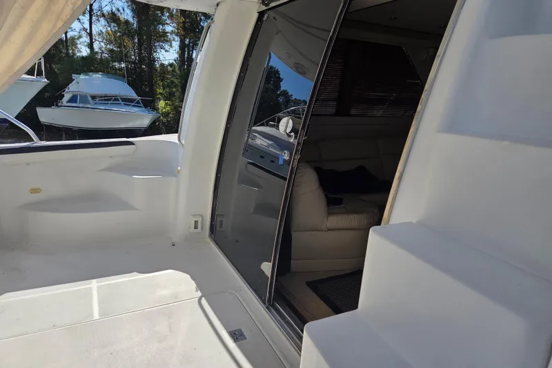 Slide: The Image of 2000 Carver 450 Voyager Pilothouse yacht interior with open sliding door and visible seating area. - 16