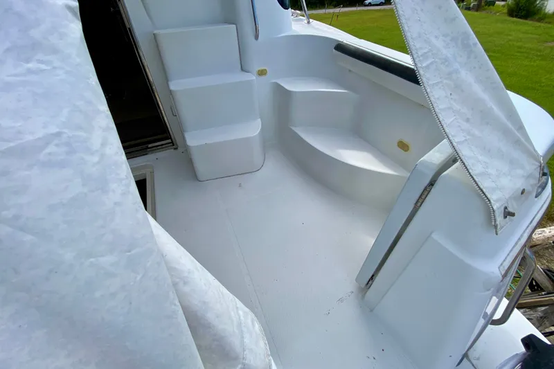 Slide: The Image of 2000 Carver 450 Voyager Pilothouse deck with white seating and steps. - 22