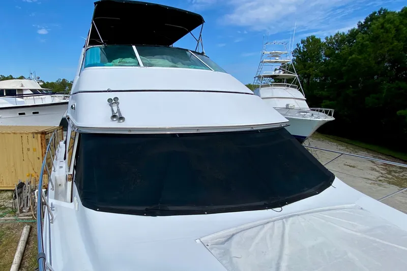 Slide: The Image of 2000 Carver 450 Voyager Pilothouse yacht docked, featuring sleek design and spacious deck. - 75