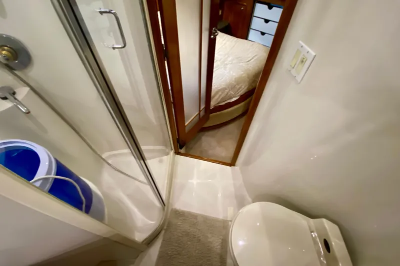Slide: The Image of Bathroom interior of 2000 Carver 450 Voyager Pilothouse yacht, featuring shower and toilet. - 50