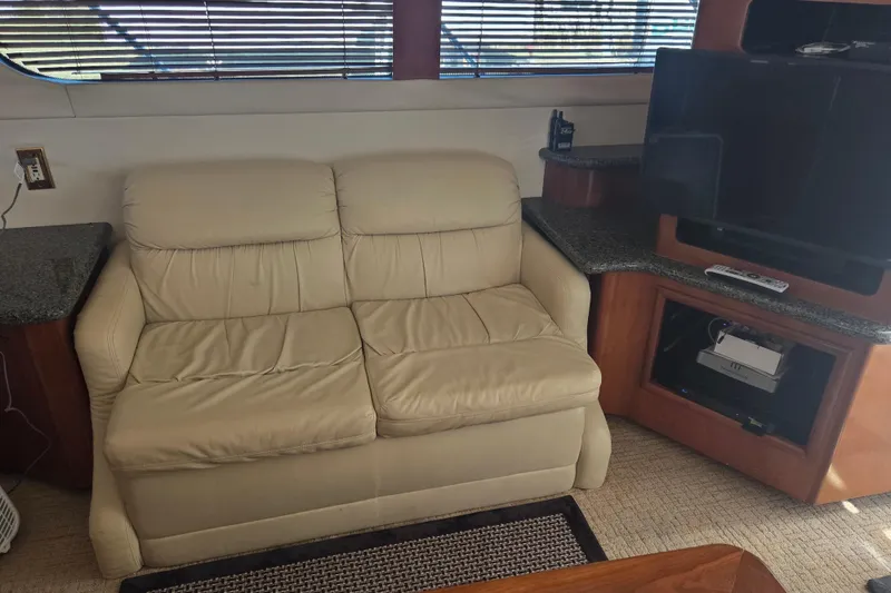 Slide: The Image of Interior of 2000 Carver 450 Voyager Pilothouse with beige sofa and TV setup. - 39