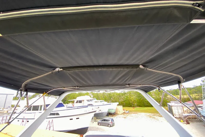 Slide: The Image of 2000 Carver 450 Voyager Pilothouse with canopy, docked in a boatyard. - 98
