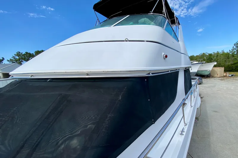 Slide: The Image of 2000 Carver 450 Voyager Pilothouse yacht with sleek design, docked outdoors under blue sky. - 80