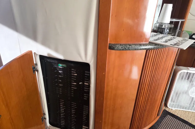 Slide: The Image of Interior of 2000 Carver 450 Voyager Pilothouse with open electrical panel and wooden cabinetry. - 49