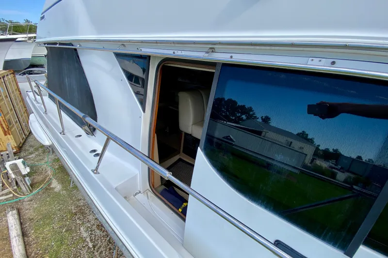 Slide: The Image of 2000 Carver 450 Voyager Pilothouse yacht with open sliding door and reflective windows. - 73