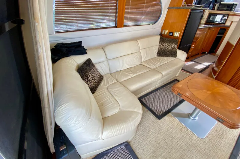 Slide: The Image of Interior of 2000 Carver 450 Voyager Pilothouse with cream leather sofa and wooden table. - 26