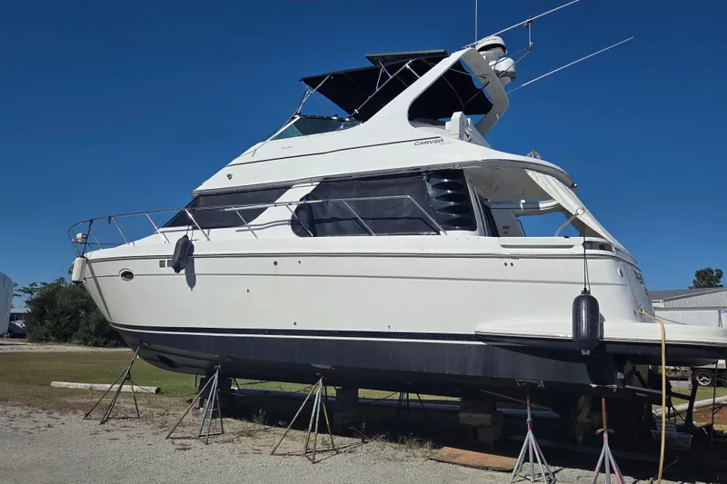 Slide: The Image of 2000 Carver 450 Voyager Pilothouse yacht on stands, clear blue sky background. - 5