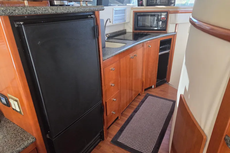 Slide: The Image of Kitchen area of 2000 Carver 450 Voyager Pilothouse with wood cabinetry and appliances. - 51