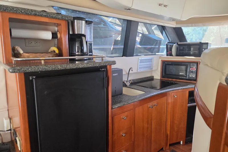 Slide: The Image of Interior of 2000 Carver 450 Voyager Pilothouse with kitchen amenities and wooden cabinetry. - 52