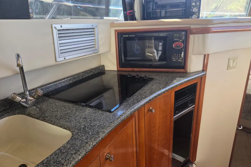 Slide: The Image of Kitchen area of 2000 Carver 450 Voyager Pilothouse with microwave and stovetop. - 54