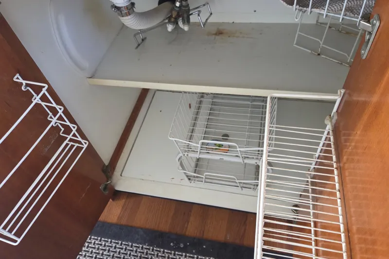 Slide: The Image of Open cabinet with wire racks and plumbing, Carver 450 Voyager Pilothouse, 2000 model. - 56