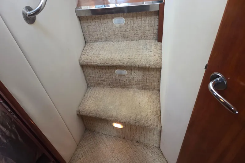 Slide: The Image of Carpeted stairs inside 2000 Carver 450 Voyager Pilothouse with handrail and lighting. - 57