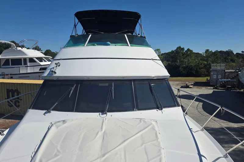 Slide: The Image of 2000 Carver 450 Voyager Pilothouse yacht docked outdoors on a sunny day. - 6