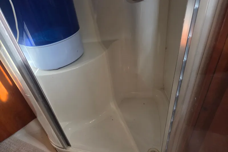 Slide: The Image of Shower area inside 2000 Carver 450 Voyager Pilothouse yacht, featuring a blue water container. - 64