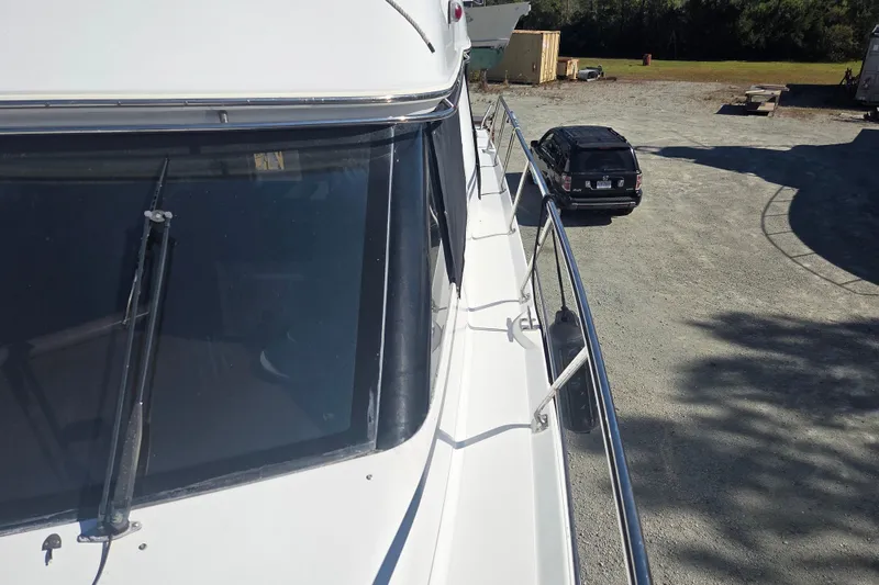 Slide: The Image of 2000 Carver 450 Voyager Pilothouse yacht docked beside a parked vehicle. - 7