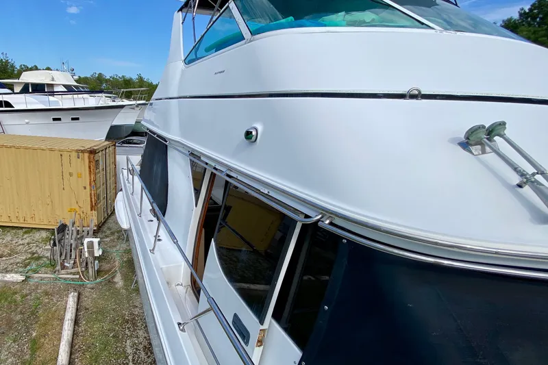 Slide: The Image of 2000 Carver 450 Voyager Pilothouse yacht docked near storage container. - 74