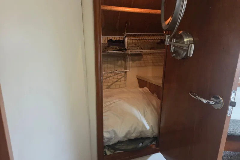 Slide: The Image of Interior of 2000 Carver 450 Voyager Pilothouse showing closet with bedding and shelves. - 72