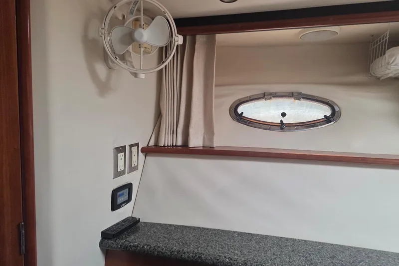 Slide: The Image of Interior of 2000 Carver 450 Voyager Pilothouse with fan, porthole, and granite countertop. - 74