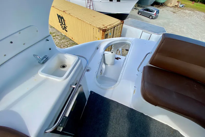 Slide: The Image of 2000 Carver 450 Voyager Pilothouse deck with sink, seating, and storage area. - 101