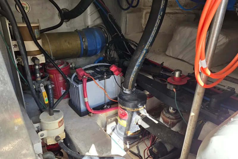 Slide: The Image of Engine room of 2000 Carver 450 Voyager Pilothouse with visible battery and hoses. - 82