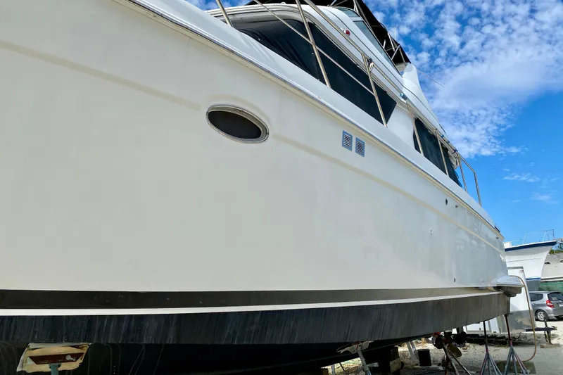 Slide: The Image of 2000 Carver 450 Voyager Pilothouse yacht on dry dock under a clear blue sky. - 15