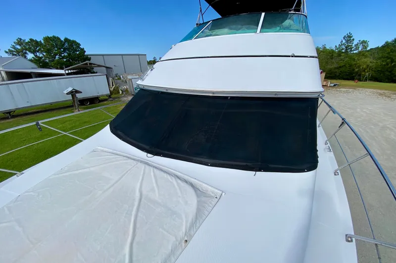 Slide: The Image of 2000 Carver 450 Voyager Pilothouse yacht with covered windshield, docked outdoors. - 79