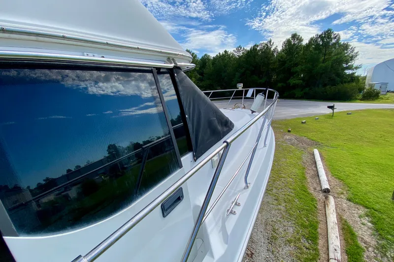 Slide: The Image of Carver 450 Voyager Pilothouse 2000 yacht docked, reflecting blue sky and clouds. - 72