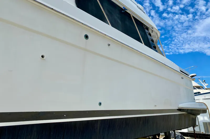 Slide: The Image of Side view of a 2000 Carver 450 Voyager Pilothouse yacht under a blue sky. - 14