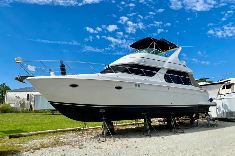 The Image of 2000 Carver 450 Voyager Pilothouse yacht on stands under a clear blue sky. - 0