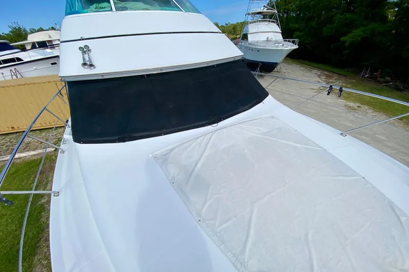 Slide: The Image of 2000 Carver 450 Voyager Pilothouse yacht docked, featuring sleek design and spacious deck. - 76