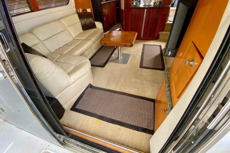 Slide: The Image of Interior of 2000 Carver 450 Voyager Pilothouse with beige leather sofa and wooden accents. - 25