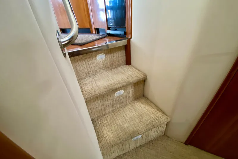 Slide: The Image of Carpeted stairs inside 2000 Carver 450 Voyager Pilothouse yacht, featuring wooden accents. - 53