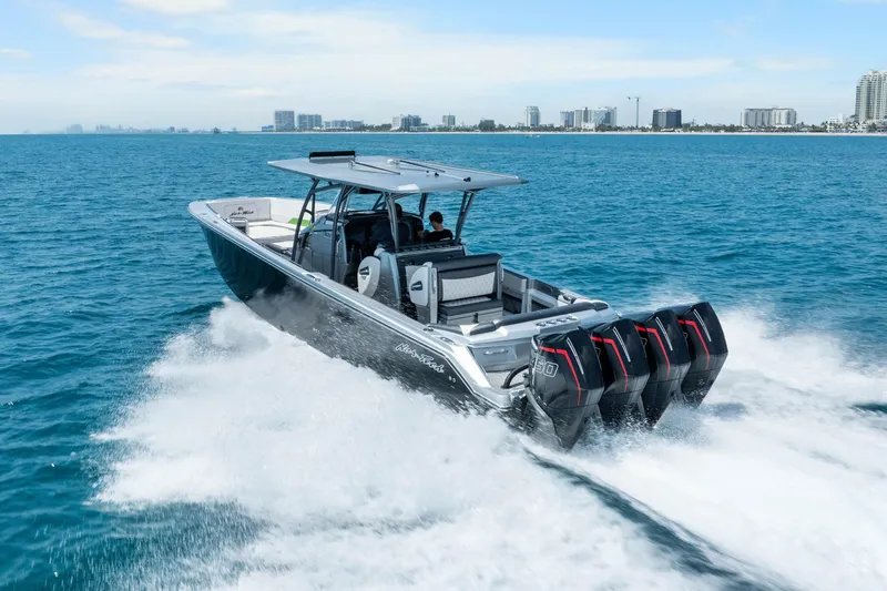 The Image of 2021 Nor-Tech 390 Sport Center Console cruising on open water with city skyline backdrop. - 1