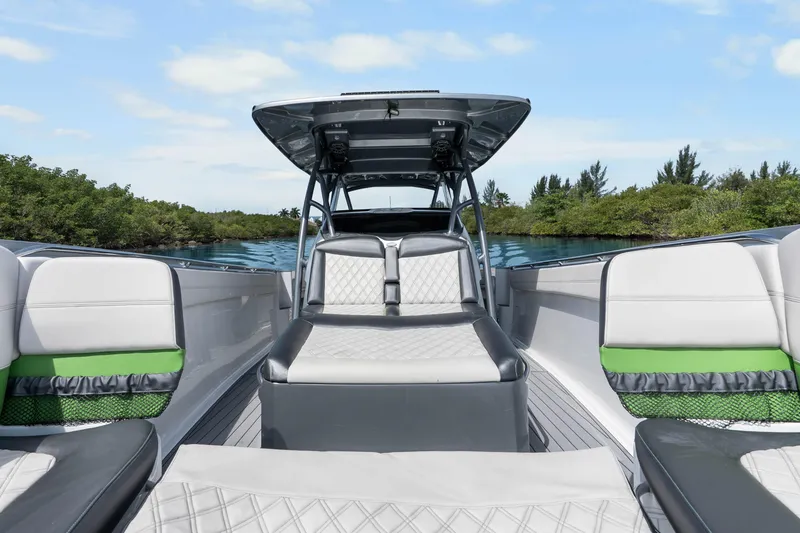 Slide: The Image of 2021 Nor-Tech 390 Sport Center Console boat interior with luxurious seating and scenic water backdrop. - 14