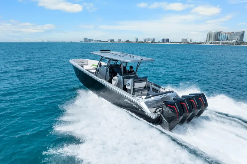Slide: The Image of 2021 Nor-Tech 390 Sport Center Console cruising on open water, city skyline in background. - 2