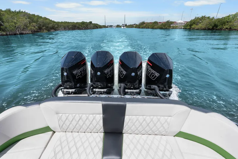 Slide: The Image of 2021 Nor-Tech 390 Sport Center Console with quad engines cruising on a scenic waterway. - 23