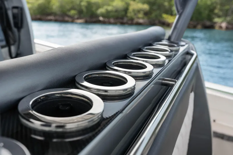 Slide: The Image of 2021 Nor-Tech 390 Sport Center Console boat with sleek cup holders, near water and greenery. - 25