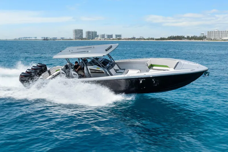 Slide: The Image of 2021 Nor-Tech 390 Sport Center Console speeding on ocean, city skyline in background. - 3
