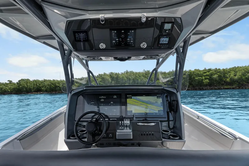 Slide: The Image of 2021 Nor-Tech 390 Sport Center Console boat dashboard with navigation screens on open water. - 31