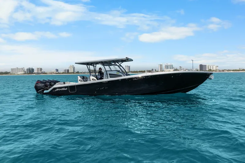 Slide: The Image of 2021 Nor-Tech 390 Sport Center Console boat on clear blue water, city skyline in background. - 37
