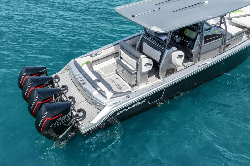 Slide: The Image of 2021 Nor-Tech 390 Sport Center Console boat with quad engines on clear blue water. - 40
