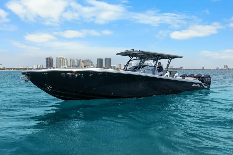 Slide: The Image of 2021 Nor-Tech 390 Sport Center Console boat on clear blue water with city skyline. - 45