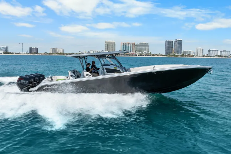 Slide: The Image of 2021 Nor-Tech 390 Sport Center Console cruising on blue ocean near city skyline. - 48