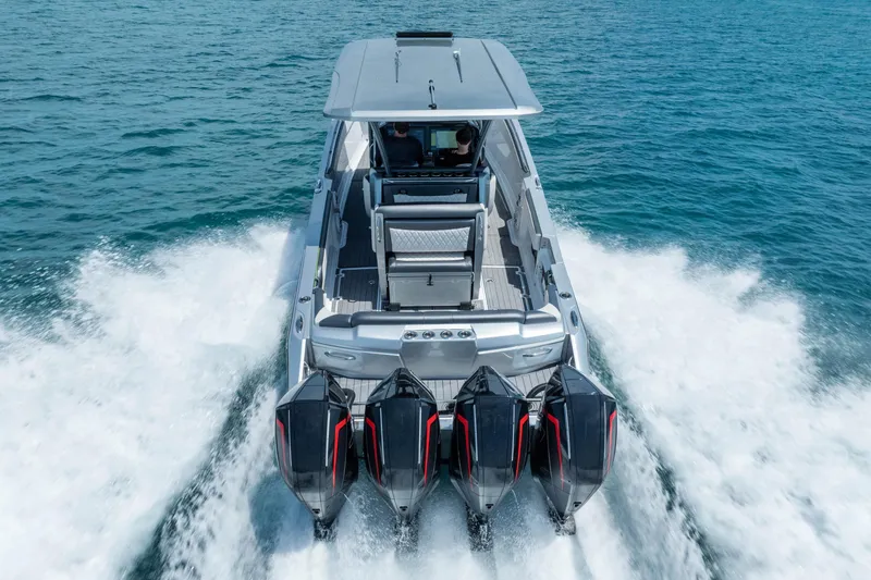 Slide: The Image of 2021 Nor-Tech 390 Sport Center Console boat cruising on open water with four powerful engines. - 50