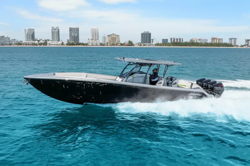 Slide: The Image of 2021 Nor-Tech 390 Sport Center Console cruising on blue ocean near city skyline. - 52