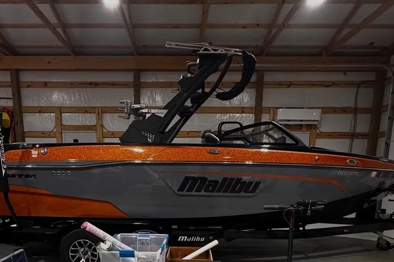Slide: The Image of 2023 Malibu Wakesetter 23 LSV boat in a garage, orange and gray design. - 3