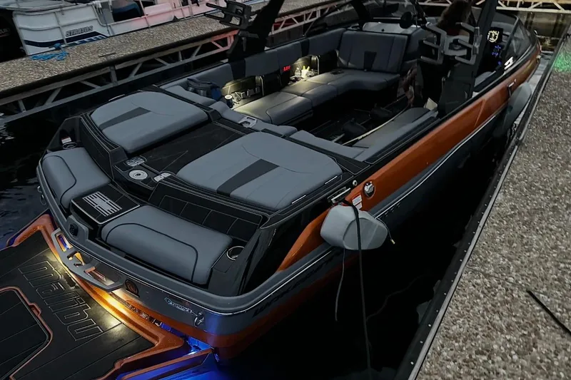 Slide: The Image of 2023 Malibu Wakesetter 23 LSV boat docked, featuring sleek design and illuminated interior. - 4
