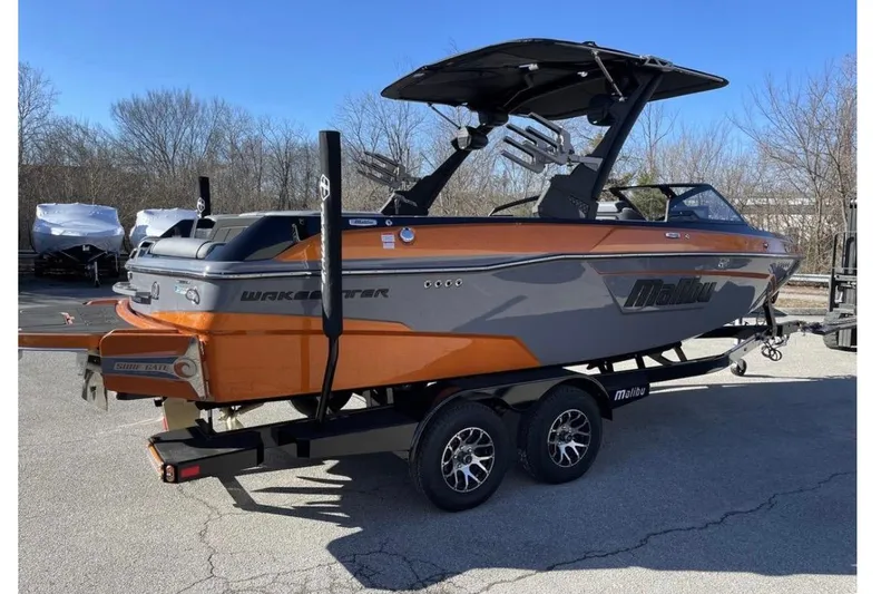 Slide: The Image of 2023 Malibu Wakesetter 23 LSV boat on trailer, orange and gray design. - 5