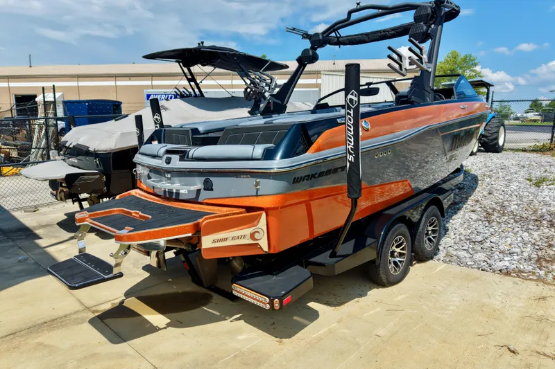 Slide: The Image of 2023 Malibu Wakesetter 23 LSV boat on trailer, featuring vibrant orange and gray design. - 13